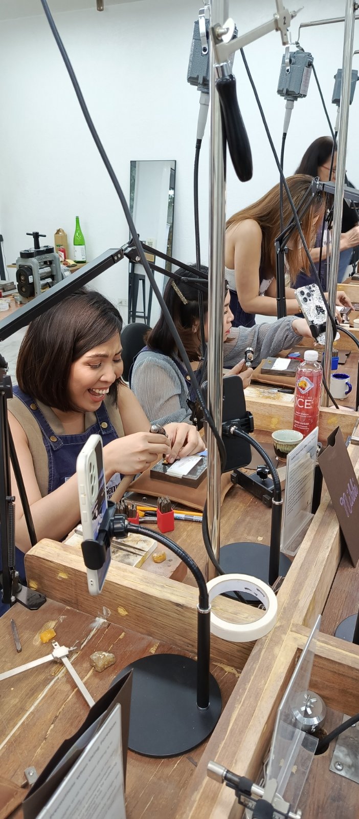 Bridal shower jewelry making person working on jewelry in a workshop with tools and materials around.